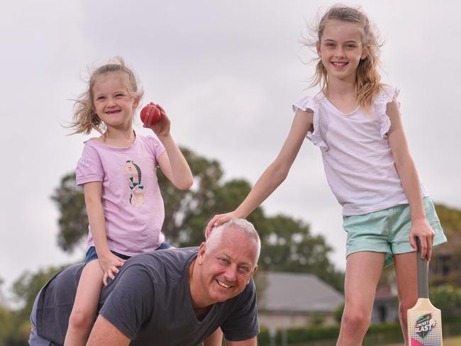 AAP/Inner West CourierL-R Natalia Graham 7 yrs;  Aaron Graham and Aurelia Graham 8 yrs pose for photo at Drummoyne Oval on Friday 10.01.2020.Aaron Graham and his two daughters will be enrolling in a new father and daughters cricket program at Abbotsford.(AAP / Flavio Brancaleone)