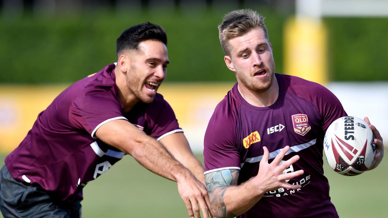 Cameron Munster (right) gets past Corey Norman during Queensland State of Origin training at Langlands Park in Brisbane.