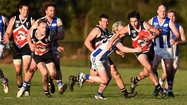 Peninsula Football league Bonbeach v Langwarrin. Bonbeach player #25 Daniel Smith slips a Langwarrin tackle. Picture: Chris Eastman