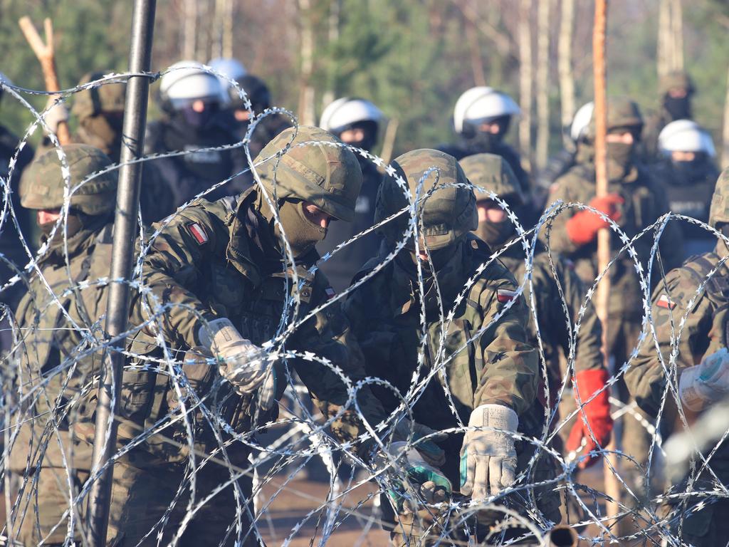 Poland’s security personnel behind a barbed wire fence. Picture: Leonid Shcheglov/BELTA/AFP