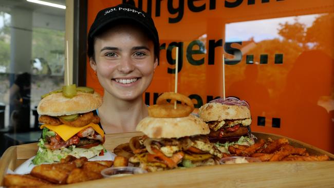 Tahlia Piccirillo with Collective Burger, Tree Hugger Burger and Halloween Burger at Just Poppy’s, Riverhills. Picture: AAP/David Clark