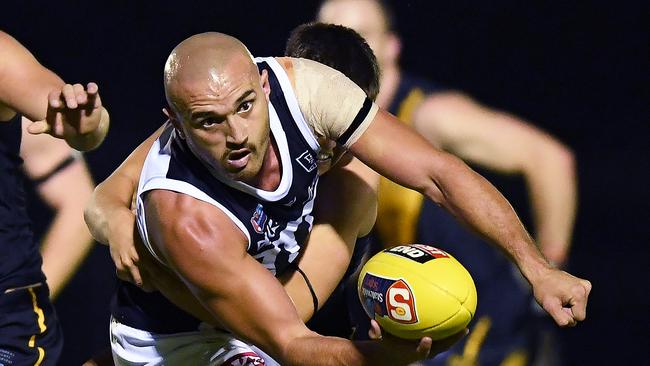 Sam Powell-Pepper fires out a handpass during a SANFL game.