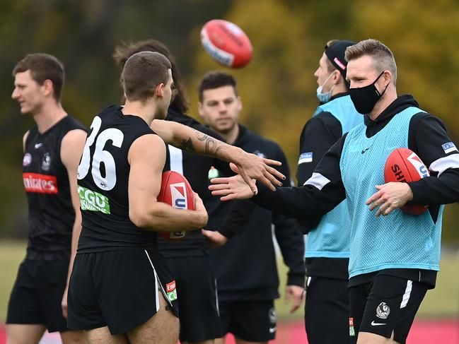 MELBOURNE, AUSTRALIA - JUNE 01: Magpies head coach Nathan Buckley high fives Brayden Sier of the Magpies during a Collingwood Magpies AFL training session at Holden Centre on June 01, 2021 in Melbourne, Australia. (Photo by Quinn Rooney/Getty Images)