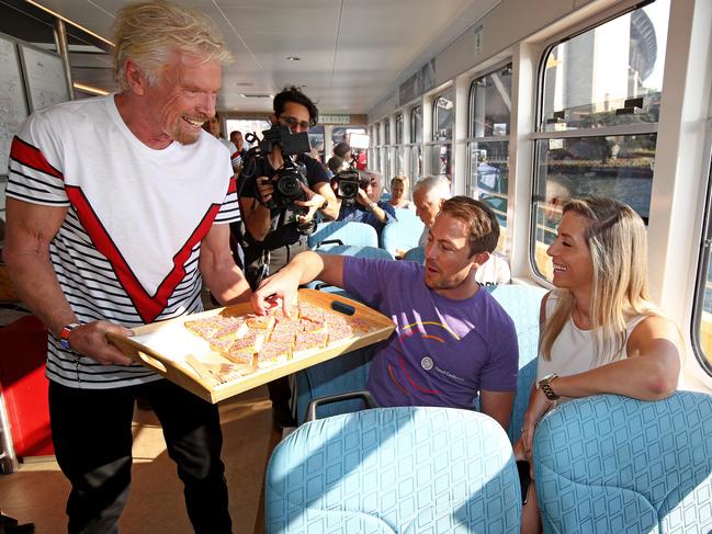 Sir Richard Branson greets commuters to announce Virgin Voyages and Virgin Australia will offer flight and cruise packages for Aussies wanting to cruise the Caribbean. Picture: Toby Zerna