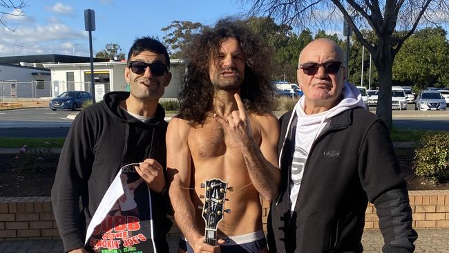 Mr Caruso (centre) celebrates outside the Elizabeth Magistrates Court as only he can with his brother and father after his charges were dismissed. Picture: Brinley Duggan