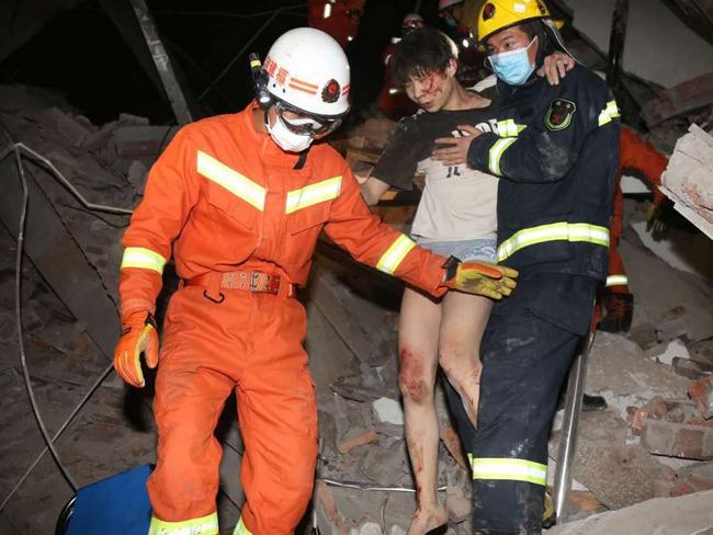 Rescuers help a woman from the rubble of a collapsed hotel building in Quanzhou city. Picture: AP