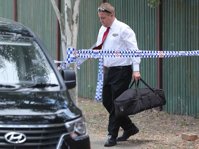 A funeral company staff member leaves the scene with a bag. Police at a crime scene at Sunray Street in Sunnybank Hills.  Pic Peter Wallis