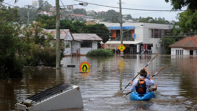 A fridge floats down the street in the central Brisbane suburb of Rosalie on Wednesday, January 12, 2011.