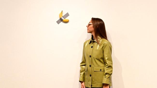 A visitor takes in an artwork titled Comedian by Italian artist Maurizio Cattelan at the NGV Triennial. Picture: AFP