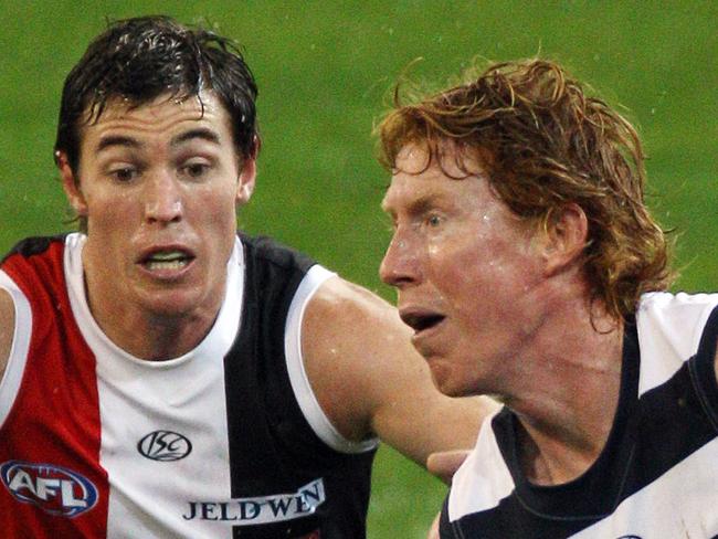 St Kilda v Geelong. MCG. Cameron Ling handballs before Lenny Hayes tackles.