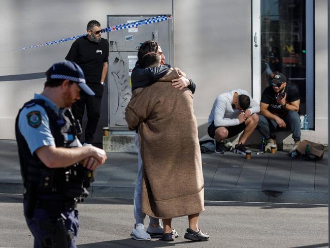 Men believed to be friends and relatives of Tarket Ayoub grieve at the site of the shooting on Monday. Max Mason-Hubers