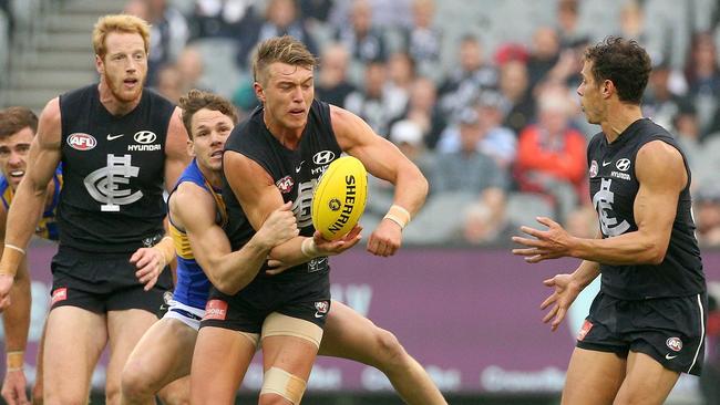 Patrick Cripps is tackled by Jack Redden as he gets handball away. Picture: AAP