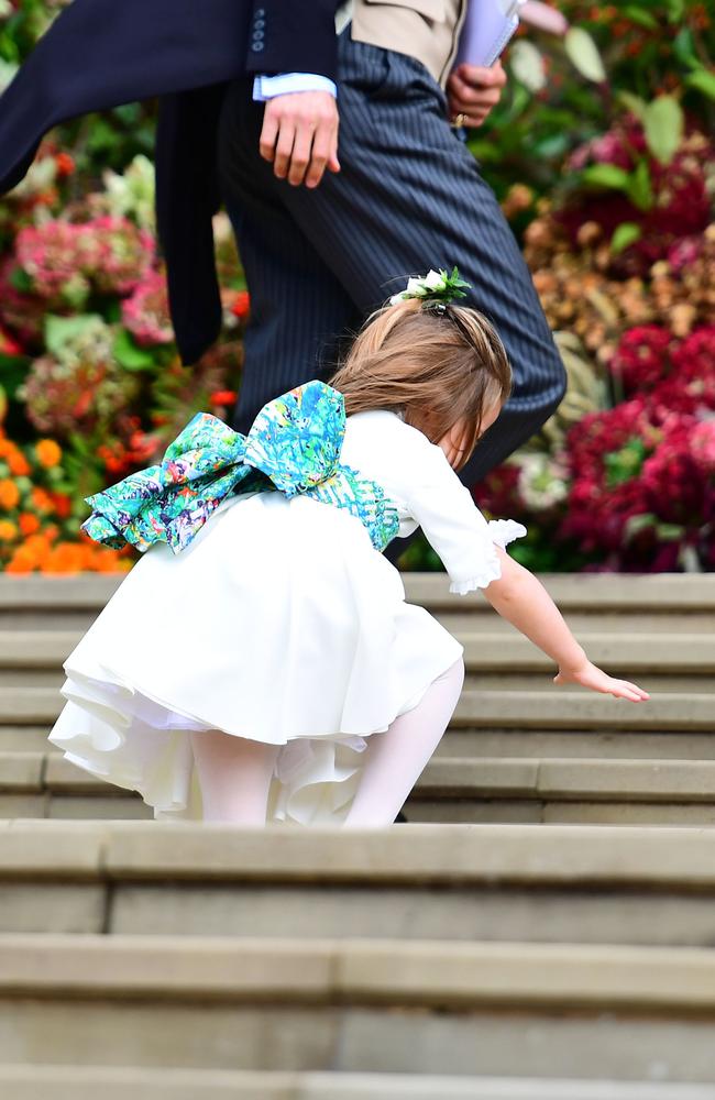 Bridesmaid Princess Charlotte of Cambridge falls on the steps as she arrives to take part in the wedding of Britain's Princess Eugenie of York to Jack Brooksbank at St George's Chapel, Windsor Castle, in Windsor, on October 12, 2018. (Photo by Victoria Jones / POOL / AFP)