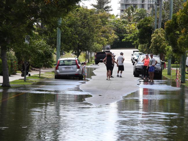 Flooding from the King tide at Budds Beach at Surfers Paradise was made worse by the approaching storm system. Locals watch the water rise. Picture Glenn Hampson