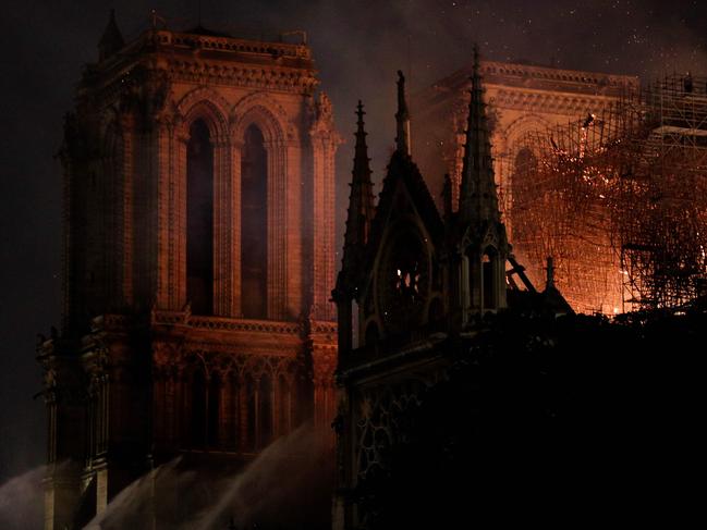 Firefighters douse flames rising from the roof at Notre-Dame Cathedral in Paris on April 15, 2019. - A fire broke out at the landmark Notre-Dame Cathedral in central Paris, potentially involving renovation works being carried out at the site, the fire service said. (Photo by Geoffroy VAN DER HASSELT / AFP)