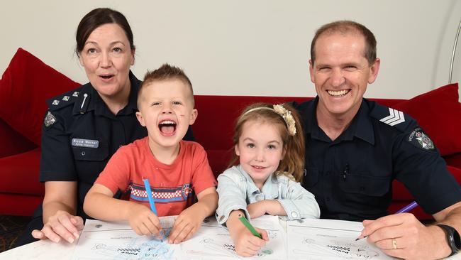 Cousins Archie and Lily get involved in the Victoria Police colouring competition with Acting Insp Nicole Warner and Sgt Richard Farrelly. Picture: Lawrence Pinder
