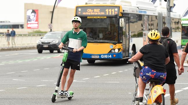 A Lime user rides a scooter across Victoria Bridge in Brisbane’s CBD. Picture: AAP/Albert Perez