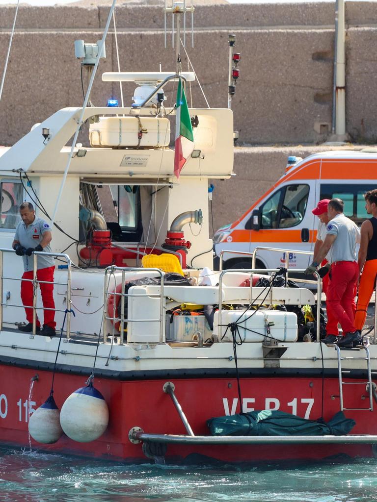 Italian firefighters transport a body bag with a victim after a superyacht sank off the coast of Porticello. (Photo by Igor Petyx / ANSA / AFP)