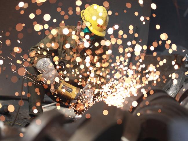 TOPSHOT - This photo taken on July 15, 2023 shows a worker welding metal at a factory in Hangzhou in China's eastern Zhejiang province. China's economy grew 6.3 percent year on year in the second quarter, a figure that belies the country's slowing post-pandemic recovery and one that analysts warn is inflated given the low base of comparison with lockdown-wracked 2022. (Photo by AFP) / China OUT