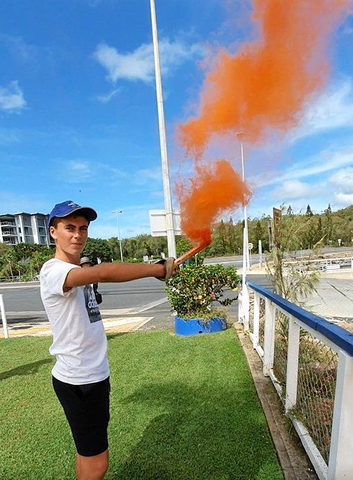 Oliver Weeks using the orange smoke flare. Picture: Yeppoon Coast Guard