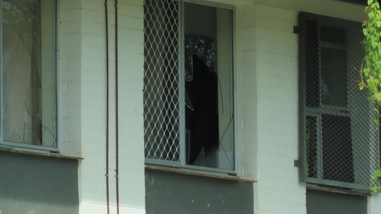 Nearby housing complexes are visibly peppered with busted windows and doors.