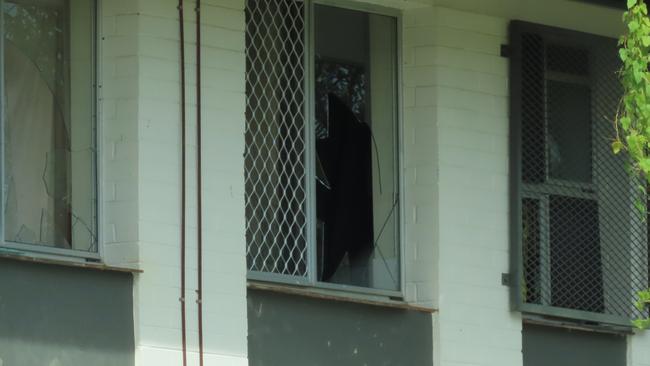 Nearby housing complexes are visibly peppered with busted windows and doors.