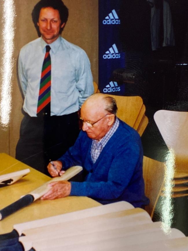 Sir Donald Bradman signing the cricket bats in 1998.