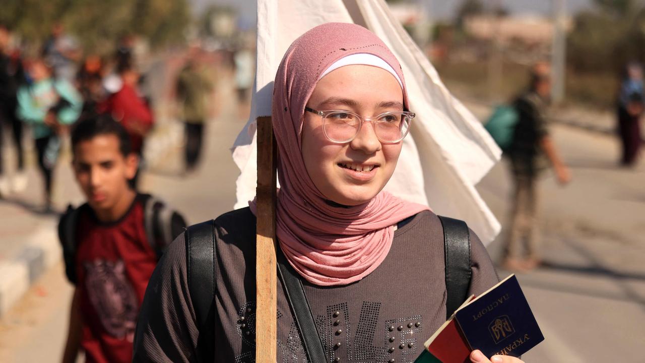 A woman carries passports and a white flag as Palestinians flee Gaza City. Picture: AFP