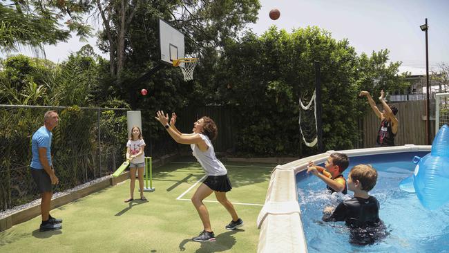 Mark and Helene Clarkson at home with their children and neighbours in Brisbane’s Coorparoo. Picture: Russell Shakespeare