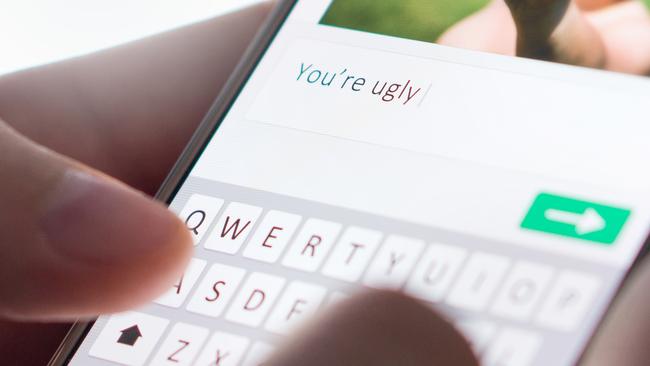 Internet troll sending mean comment to picture on an imaginary social media website with smartphone. Cyber bullying and bad behavior online concept.