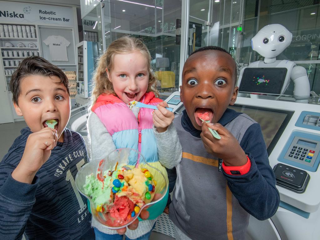 L-R Harry Brunne, 7
Millie Baker, 7
Kibunja Kiarie ,8. Australia's first robot retail store is opening on Tuesday at Federation Square. Three robots take your order, scoop the ice cream and serve you. Picture: Jason Edwards