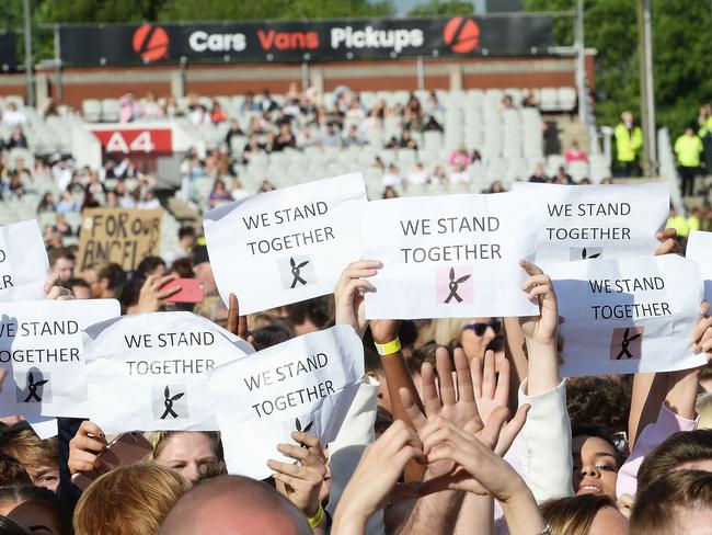 Fans hold We Stand Together placards at the One Love Manchester tribute concert. Picture: Dave Hogan via AP