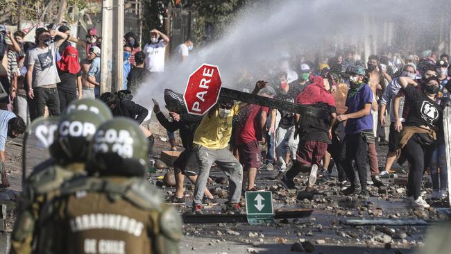 Demonstrators demanding food aid from the government clash with police in Santiago, Chile, last week. Picture: AP