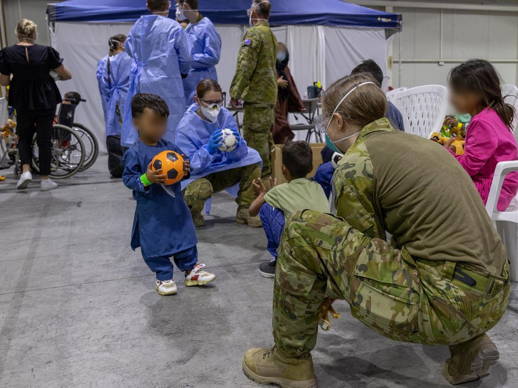 Australian Defence Force members play with children inside the evacuee handling centre. Picture: Defence