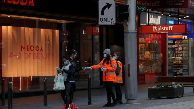 Women hand out masks to passersby in Sydney's CBD. Picture: NCA NewsWire / Dylan Coker