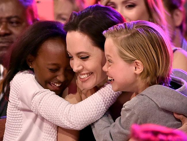 Angelina Jolie hugs daughters Zahara Marley Jolie-Pitt (L) and Shiloh Nouvel Jolie-Pitt (R) after winning award for Favorite Villain in 'Maleficent'.