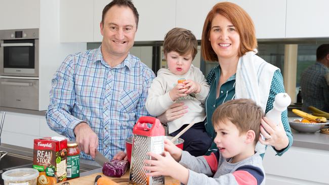 Bec Lacy with her husband Damien with their sons Angus, 2 and Harry 4 working together to prepare dinner. Picture: Sarah Matray