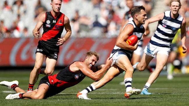 Dyson Heppell tries to stop a charging Shaun Higgins. Picture: Dylan Burns/AFL Photos via Getty Images