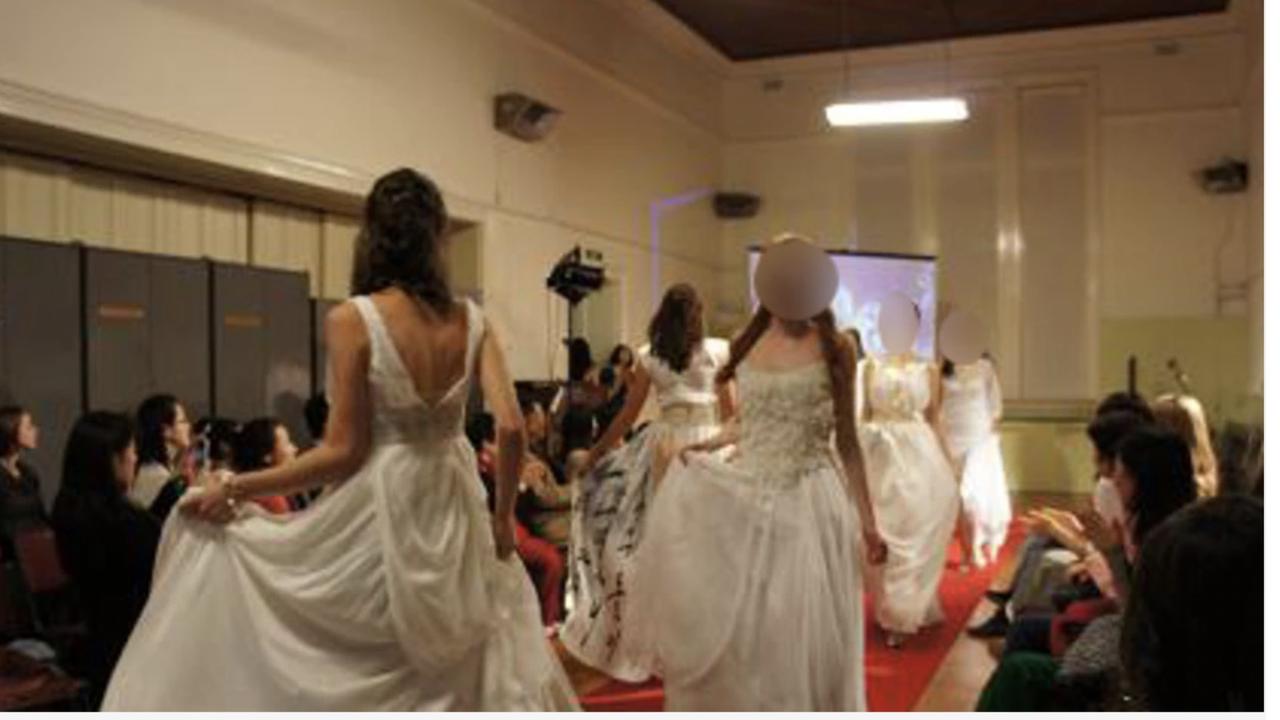 Providence members wearing bridal dresses at a modelling convention.