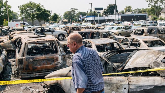 A man looks over a burnt out car lot in Kenosha after a night of civil unrest. Picture: AFP