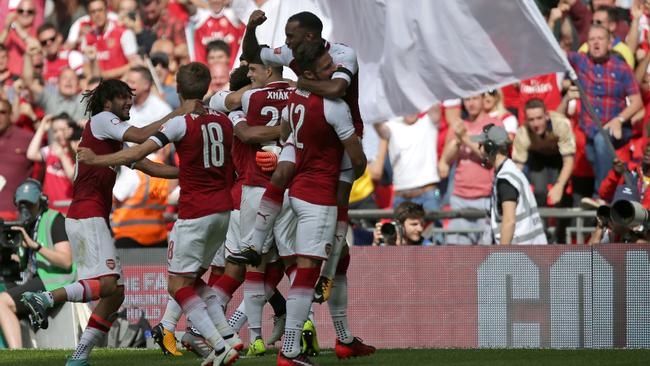 Arsenal players celebrate on the pitch after winning the penalty shoot-out.