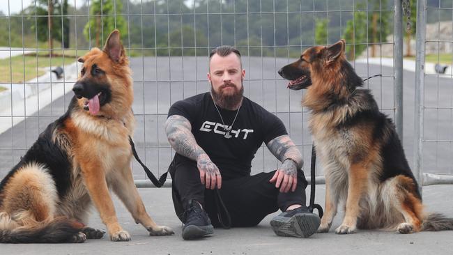 Daniel Lees and his two dogs at Elevate in Ormeau Hills, where he had signed up to purchase land with his ex partner. Picture: Glenn Hampson.