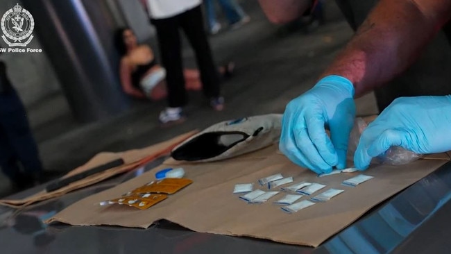 NSW Police Force Operation Northrop Sydney CBD. One woman is arrested (background) as police examine cash and white bags. Picture: NSW Police