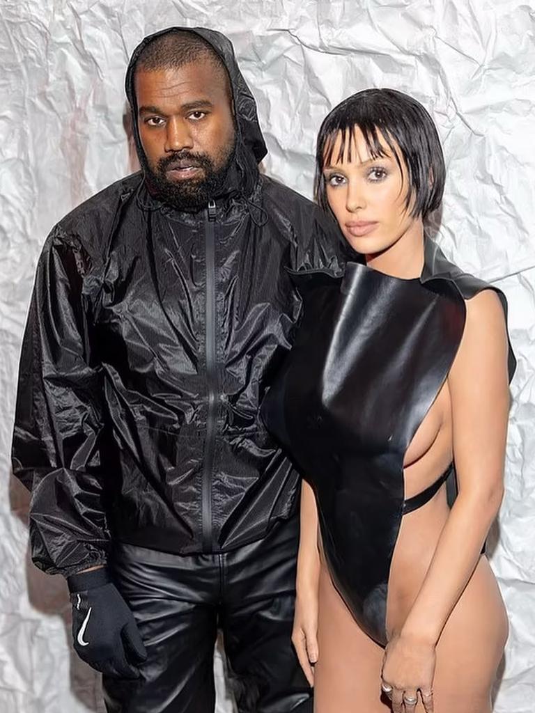 Kanye West's wife Bianca Censori goes completely underwear free under sheer  top as she recycles those crotch-flashing tights - but she does try to  cover her modesty with a phone!