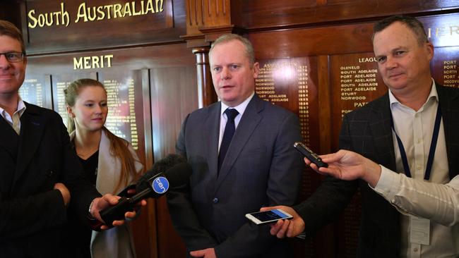 South Australian National Football League CEO Jake Parkinson (centre) speaks to the media at Adelaide Oval on Tuesday. Picture: AAP Image/David Mariuz