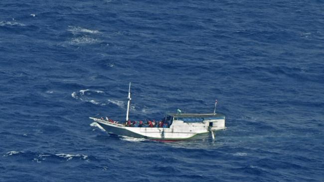 FILE - In this July 4, 2012 file photo released by the Indonesian National Search and Rescue Agency, a wooden boat which is believed to have up to 180 asylum seekers on board floats on the waters off Christmas Island, Australia. Australian officials said Saturday, July 13, 2013, a boat carrying asylum seekers from Indonesia to Australia began sinking Saturday in the Indian Ocean. Australian officials rescued 88 asylum seekers on Friday night after the boat began taking on water about 200 kilometers (120 miles) north of Christmas Island, an Australian territory 500 kilometers (310 miles) south of Jakarta, Indonesia. (AP Photo/Indonesian National Search and Rescue Agency, File)