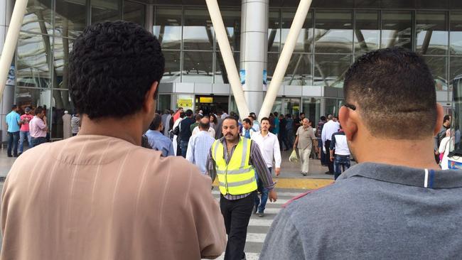 People gather outside the arrivals section of Cairo International Airport, Egypt.