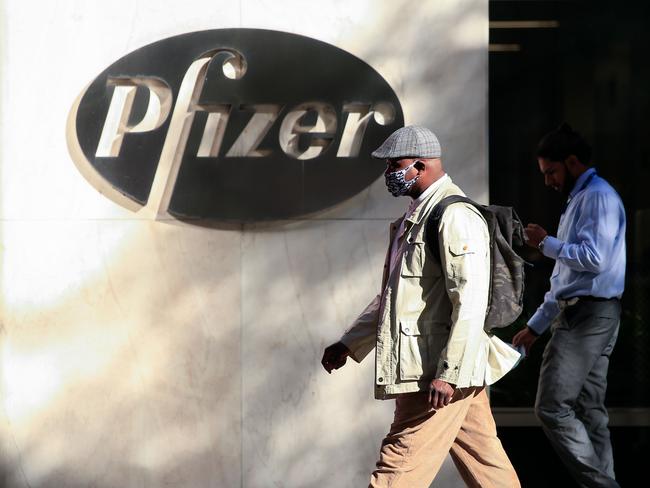 (FILES) In this file photo taken on November 9, 2020 People walk by the Pfizer world headquarters in New York. - Pfizer CEO Albert Bourla sold $5.6 million of his stock in the US pharmaceutical company on the same day it announced promising results for its Covid-19 vaccine candidate, filings showed November 11. The company, however, has reportedly said the sale was part of a pre-arranged periodic divestment plan when the stock reaches a certain price. (Photo by Kena Betancur / AFP)