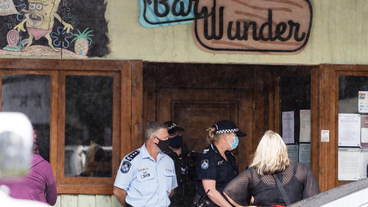 Police stand blocking the entrance to Bar Wunder as people gather on the footpath outside the Toowoomba bar shut down over failing to comply with public health orders. Picture: Kevin Farmer