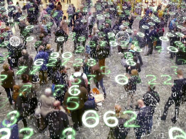 Binary code bursts from phones held by people with a matrix style overlay of glowing electronic numbers.Digital privacy generic